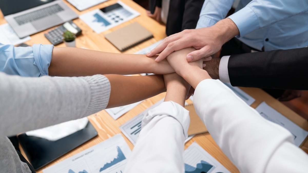 Multiracial business people make synergy hand stack together in meeting room as cooperation or team building for corporate employee in workplace. Meticulous