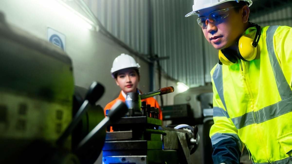 engineer cooperation Two asian maintenance engineers men and women inspect relay protection system with tablet device to control quality control process work a heavy industry manufacturing factory