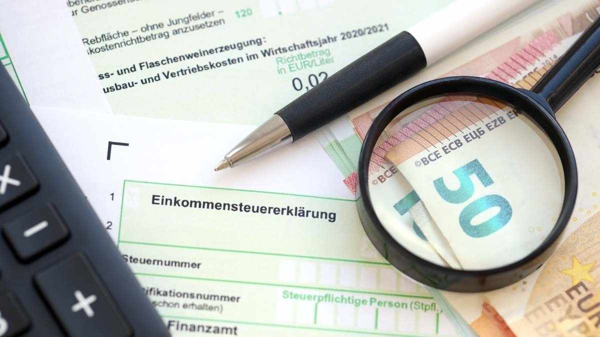 German income tax return form with pen and european euro money bills lies on accountant table close up. Taxpayers in Germany using euro currency as main to pay taxes