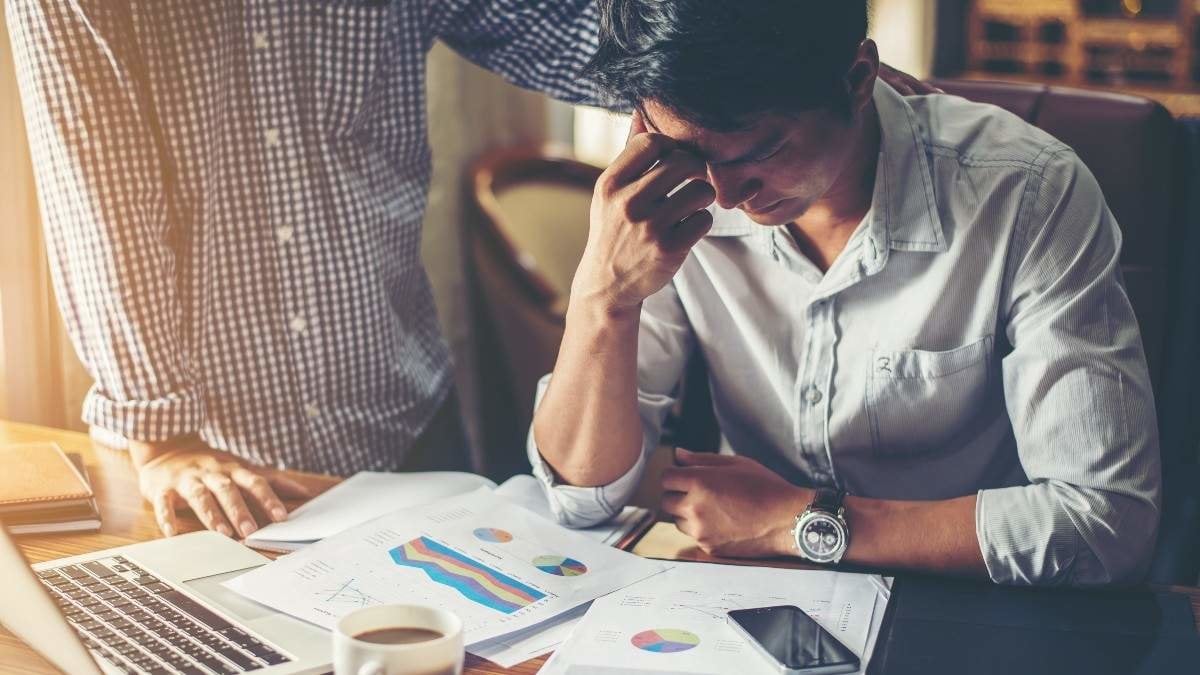 Serious young businessman looking at financial report seem like something mistake with his boss in office.