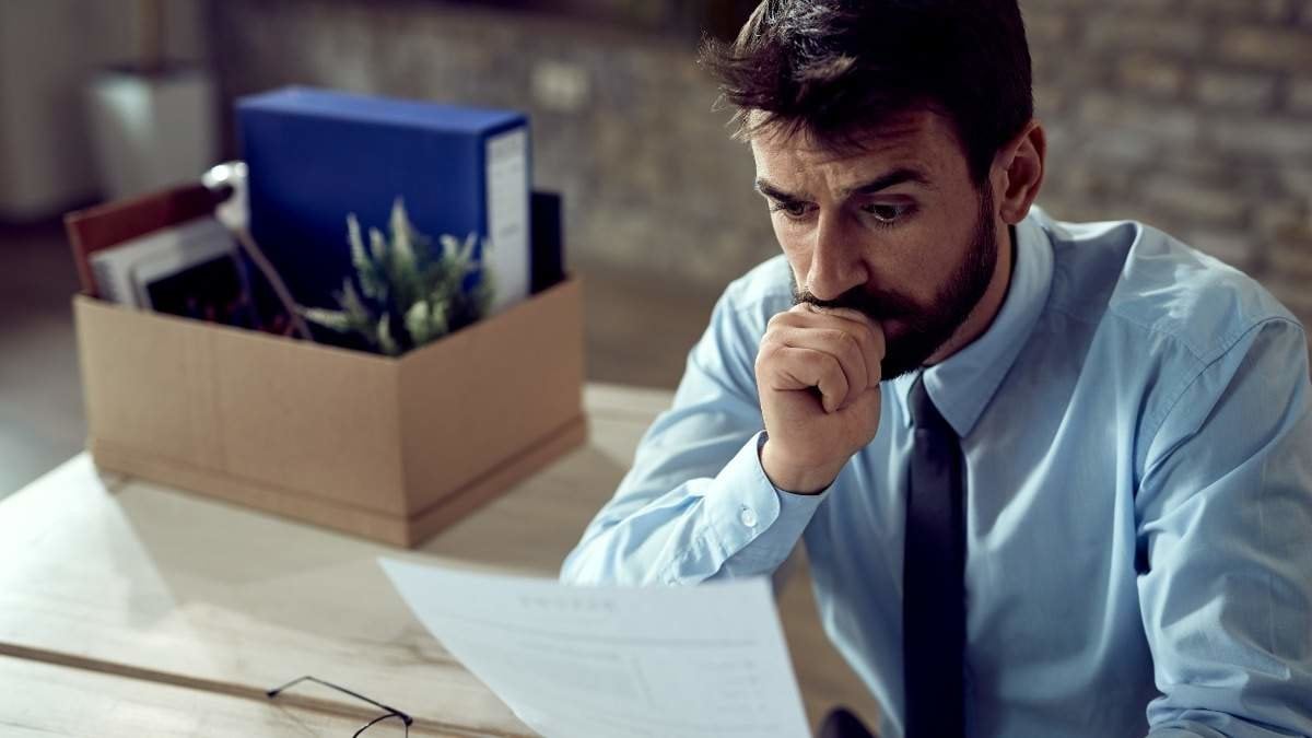 Worried businessman going through paperwork after losing his job in the office.